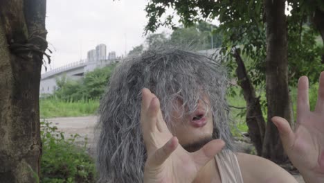 the video shows an elderly person sitting outdoors, talking to themselves in a desolate environment, with their emotions becoming increasingly excited