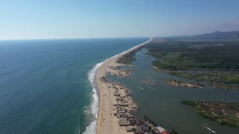 Aerial-video-of-the-coast,-a-Mexican-beach-in-complete-calm-under-the-sunset-light-accompanied-by-the-waves-of-the-sea