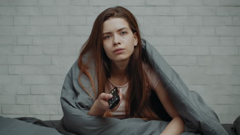 woman watching tv in bed