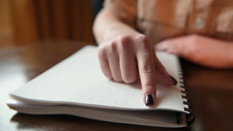 vue rapprochée d'une femme aveugle touchant du doigt les lettres d'un livre braille 1