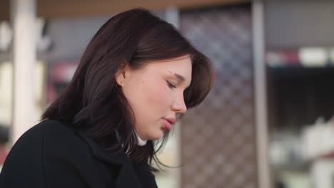 white lady with soft pink lips muttering words softly, deeply focused on something, background features an architectural structure with blurred details