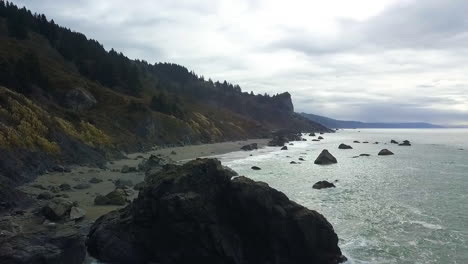 Aerial-drone-of-Northern-California-coast-on-overcast-day-with-rocks-and-evergreen-forests