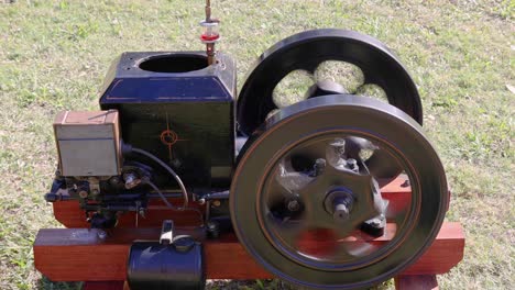 old stationary engine with rotating wheel on display