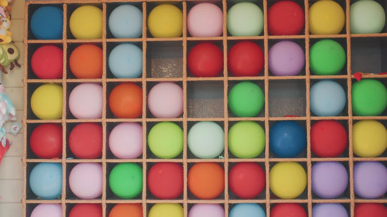 Scena di composizione di palloncini luminosa e vivace. Palloncini vivaci e multicolori organizzati all'interno di una cornice di legno. Atmosfera festiva ed energica catturata attraverso una disposizione ravvicinata di palloncini lucidi.