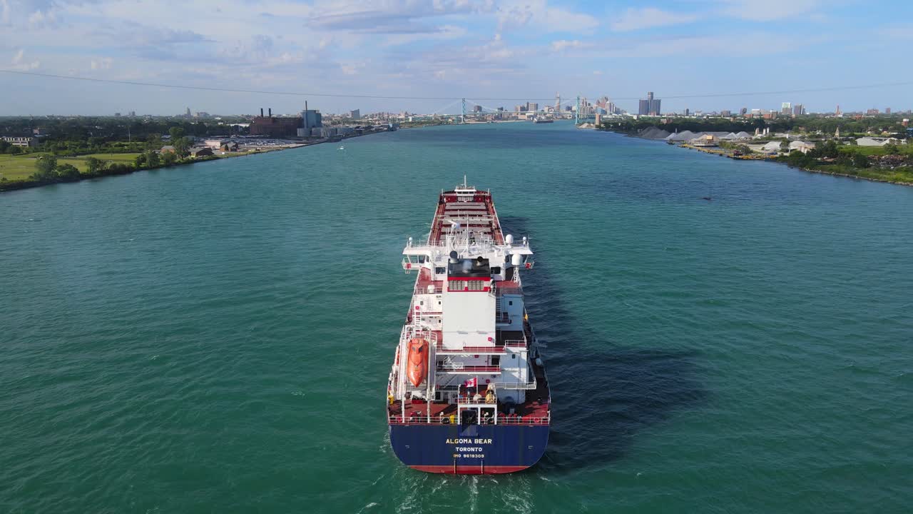 Algoma Bear vessel navigating the Detroit River with Detroit skyline in background, drone shot