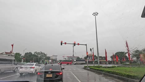 vehicles moving through a wet, busy intersection