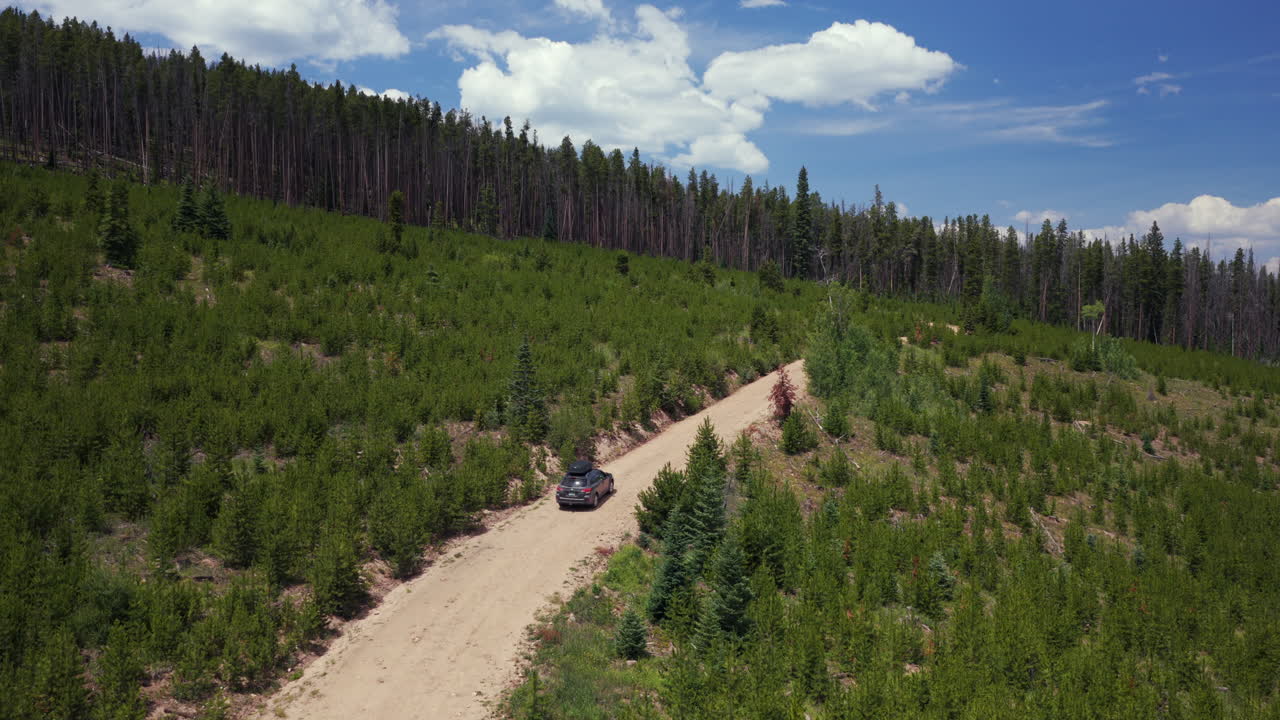 Mount of the Holy Cross Notch Mountain creek Falls Creek Trail Half moon pass AWD car driving dirt road car aerial drone Rocky Mountains Colorado Vail Minturn Red Cliff summer morning blue sky upwards