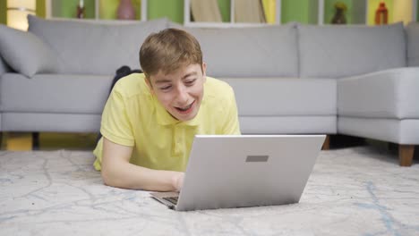 un joven hablando en su computadora portátil en casa.