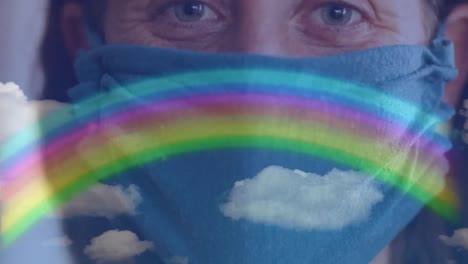 Rainbow-and-blue-sky-against-woman-wearing-face-mask
