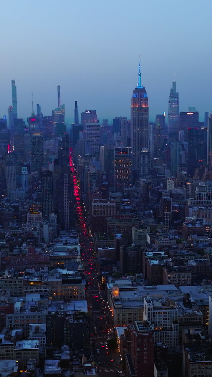Impressive New York panorama after the sunset. Hundreds of cars with red lights on in the busy streets of metropolis. Aerial view. Vertical video