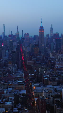 impressive new york panorama after the sunset. hundreds of cars with red lights on in the busy streets of metropolis. aerial view. vertical video