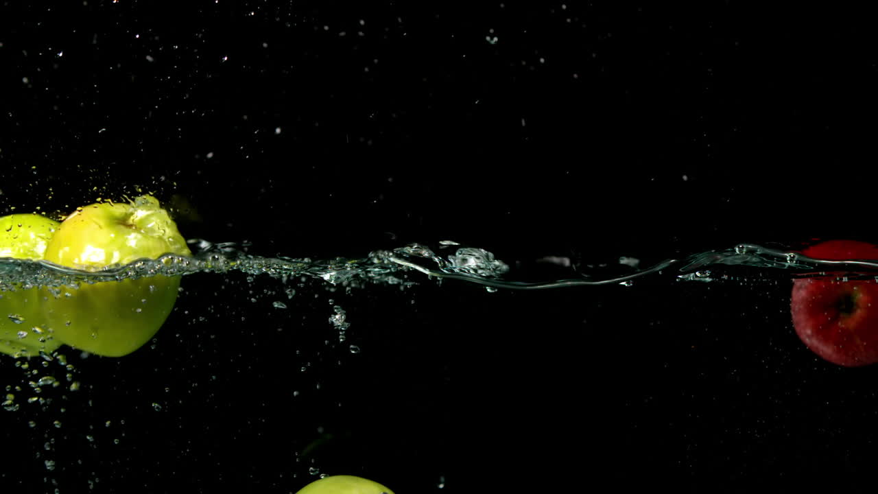 manzanas cayendo en el agua