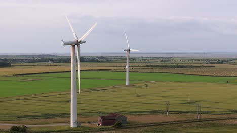 drone aerial footage of a wind turbine, windmill turning in the wind on a wind farm in the north of england showing renewable energy efficient wind power