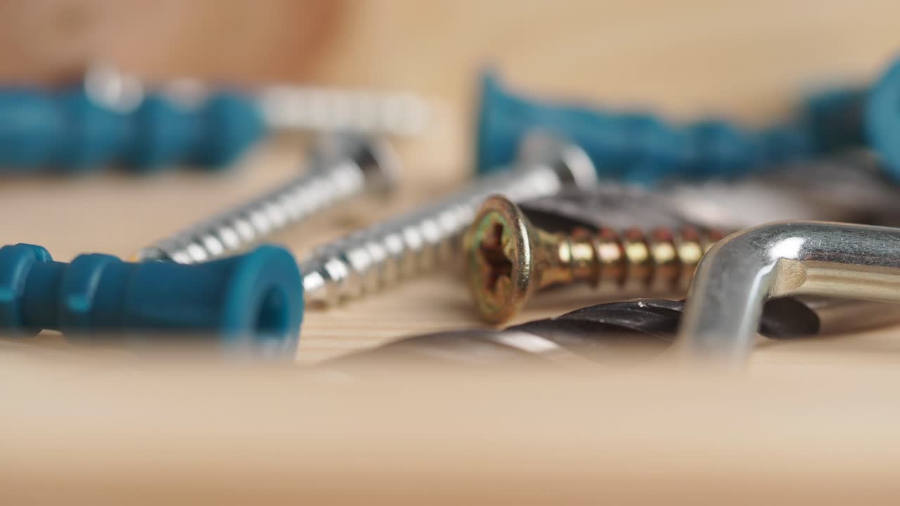Close Up of Various Screws and Hardware on Wooden Surface