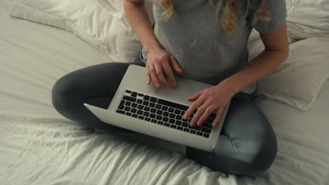 desde arriba mujer usando la computadora portátil por la mañana en la cama