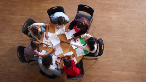 fotografía aérea de alumnos de secundaria en grupo de estudio alrededor de una mesa