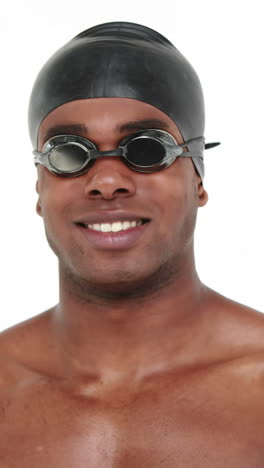 smiling swimmer with cap and goggles showing thumb up