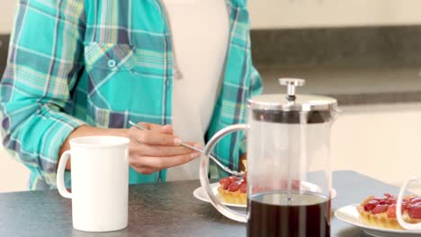 mujer sonriente tomando el desayuno