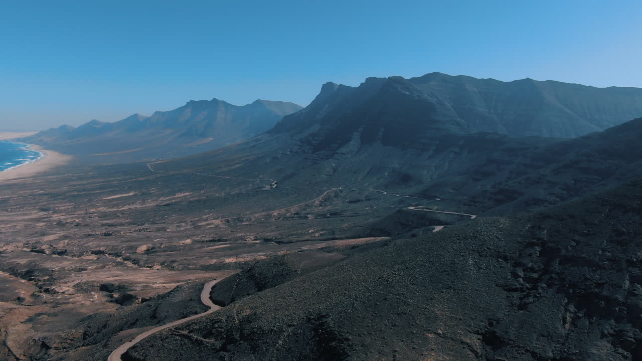 vista aérea de la playa de cofete, fuerteventura: vista aérea viajando sobre las grandes montañas y la hermosa playa