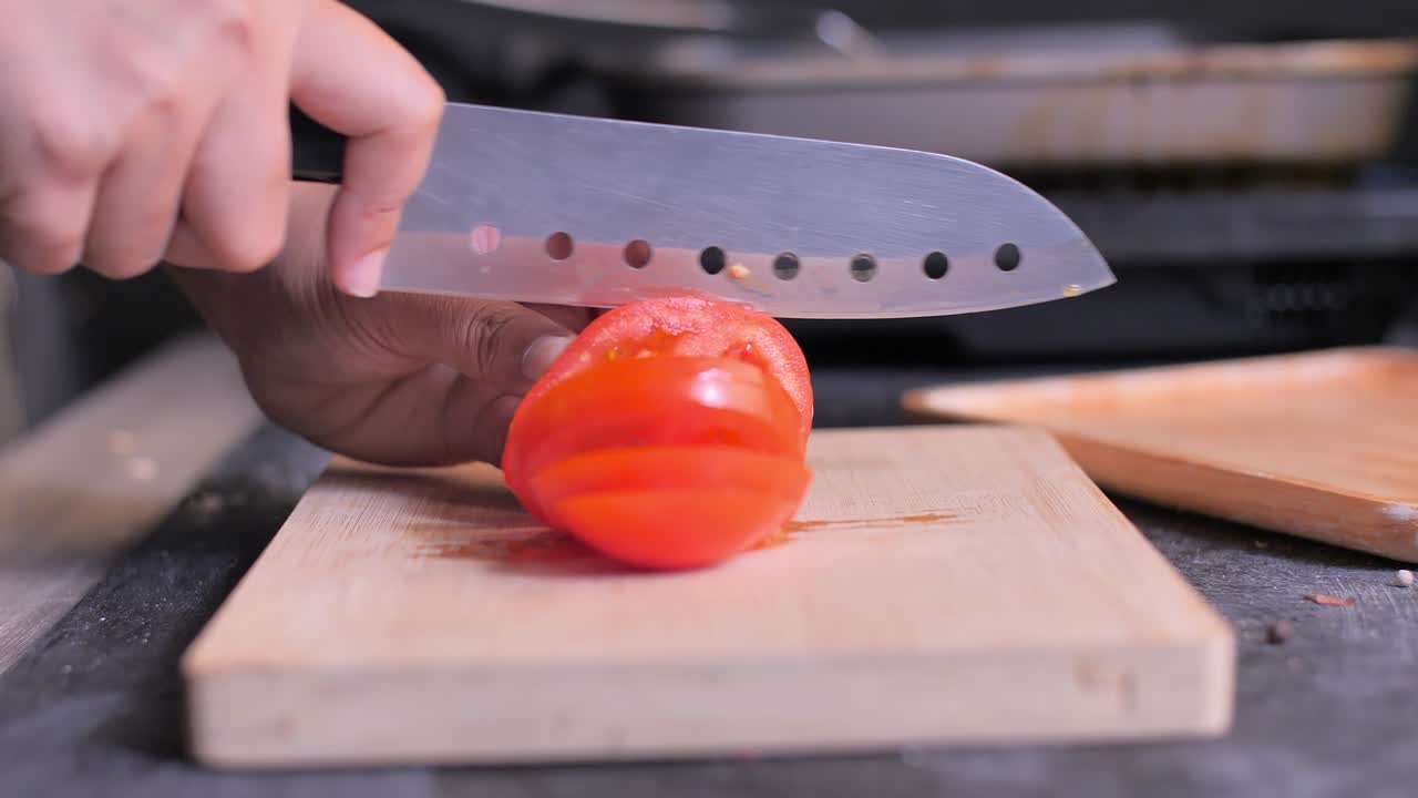 tomate cortado en primer plano en la tabla de cortar. diapositiva de la cámara
