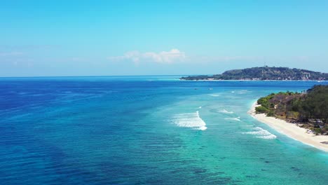 peaceful exotic beach with white sand washed by ocean waves foaming over calm clear water of turquoise lagoon in indonesia