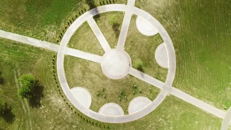 top view of a bicycle woman riding a bicycle on a circular road in a city park.