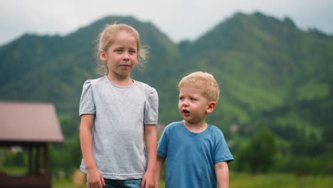 retrato de pequeños hermanos niño y niña contra grandes colinas
