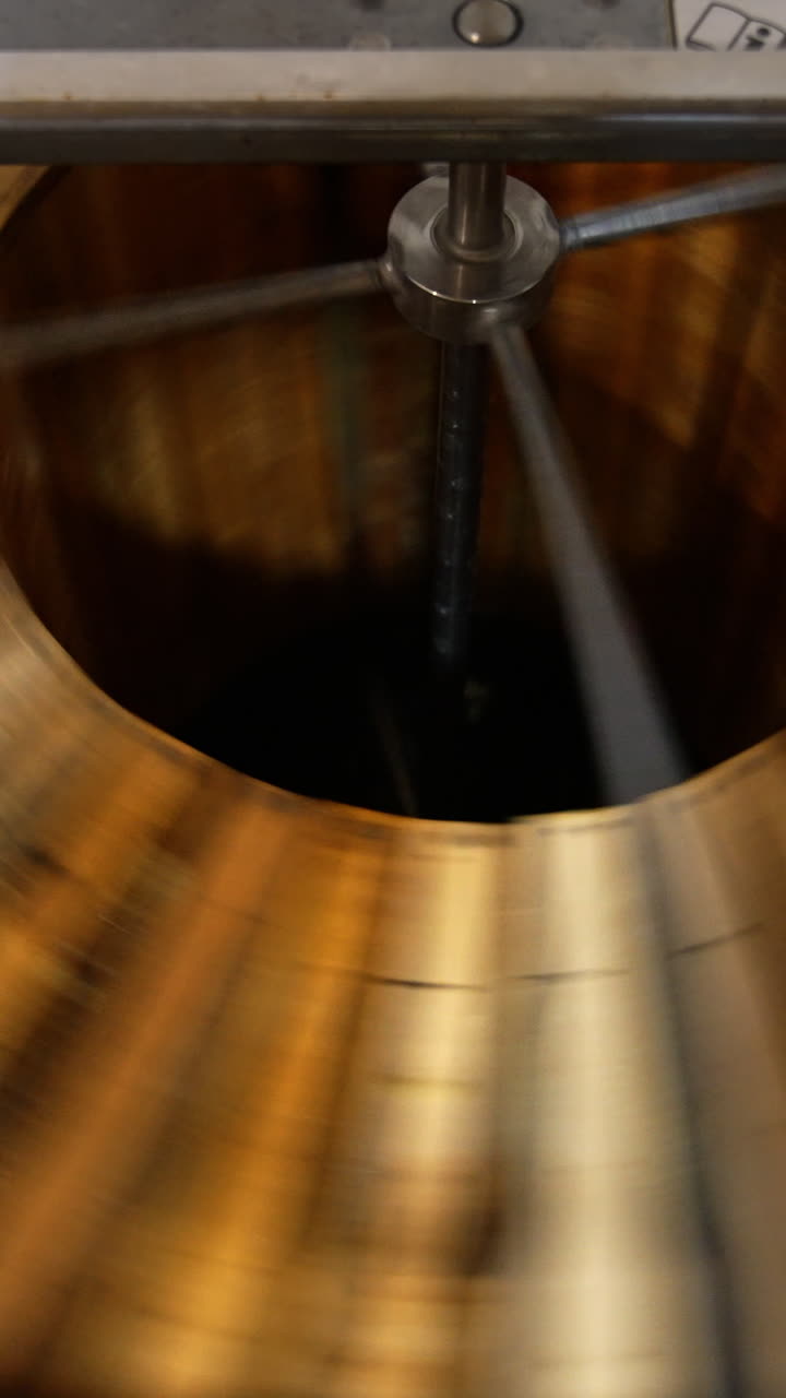 Honey extraction with the help of electric centrifuge device. Wooden frames with honeycombs spin to get rid of honey. Top view. Vertical video