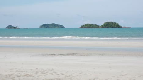 playa tropical de arena blanca con océano e islas lejanas