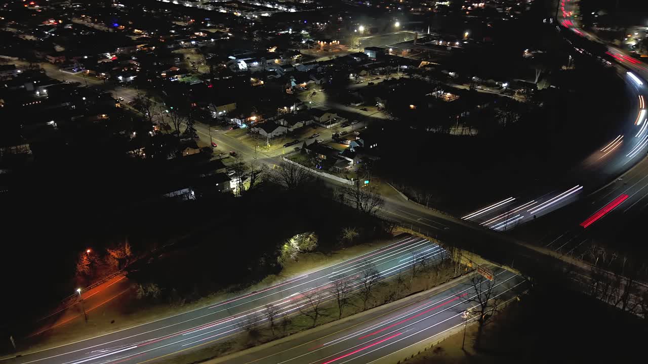 Ilmakuva hyperlapse-video ylikulkusillasta Southern State Parkway -tiellä Valley Streamissa, New Yorkissa yöllä. Kamera kallistui alas, loitoni ja kääntyi oikealle ylikulkusillalta, kun autojen valoviivat kulkivat ohi.