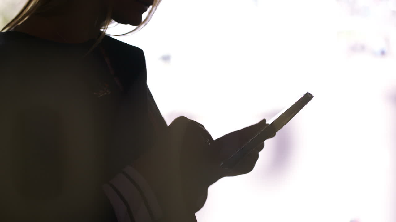 Silhouette nera di una donna con un tablet