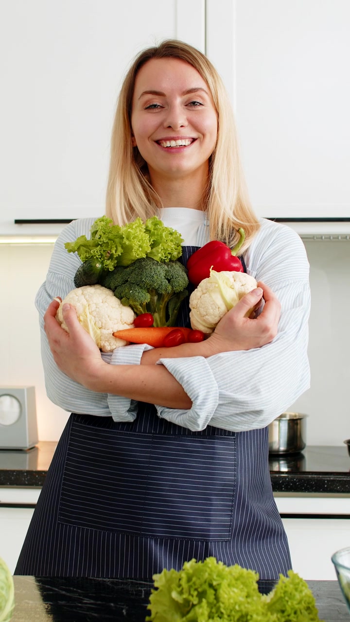 Giovane donna che tiene in mano verdure fresche dopo aver fatto la spesa, promuovendo una dieta chetogenica sana in cucina.