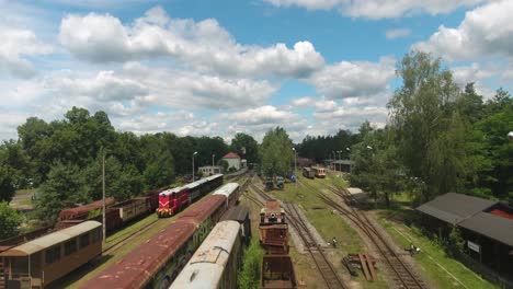 Dynamische-Drohnenaufnahme-Einer-Alten-Eisenbahnstrecke-Mit-Rostigen-Zügen