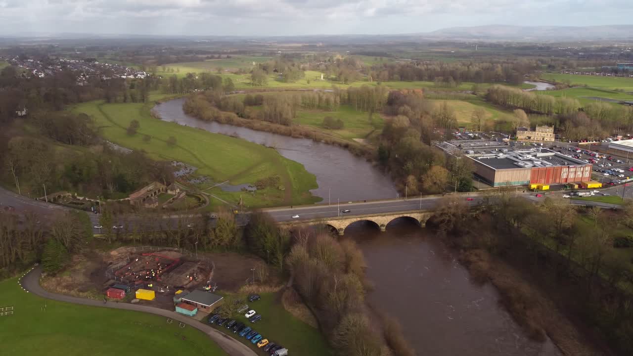 Traffic passing on Eden Bridge over Eden River with Rickerby Park in background - Carlisle, England