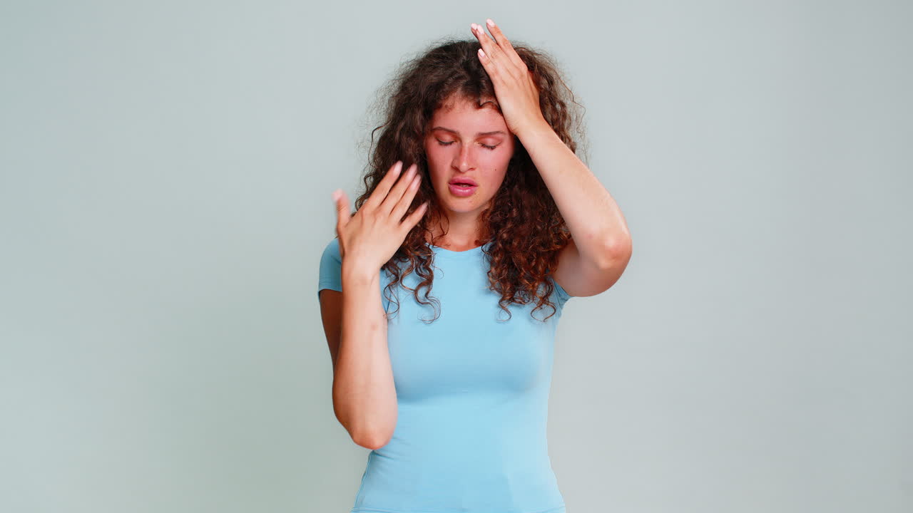 Woman suffering headache stress holding head closing eyes painful tired exhausted facial reaction