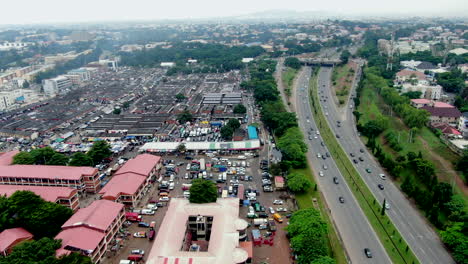 wuse market and the nearby highway in abuja, nigeria - sliding aerial flyover