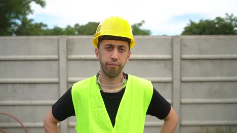 Front-Portrait-Of-Laborer-Looking-At-Camera,-Wearing-Hard-Hat-And-Reflective-Safety-Vest