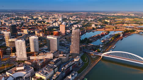 bratislava skyline on a clear day. high above bratislava, modern buildings shine against the blue sky, showcasing the vibrant urban landscape and river