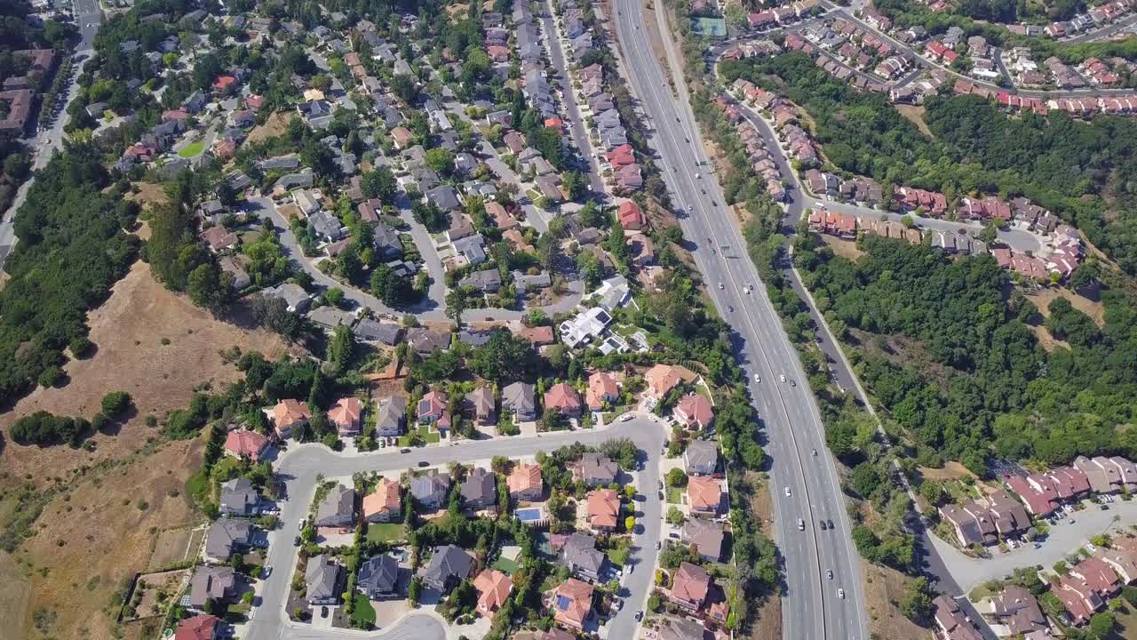 Timelapse aereo fisso di case e autostrada nei sobborghi della contea di San Mateo, nell'area della Baia di San Francisco, California, USA