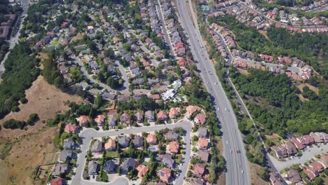 timelapse aerial hold shot of houses and highway in suburbs of san mateo county, sf bay area california, usa