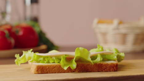 making a ham and lettuce sandwich