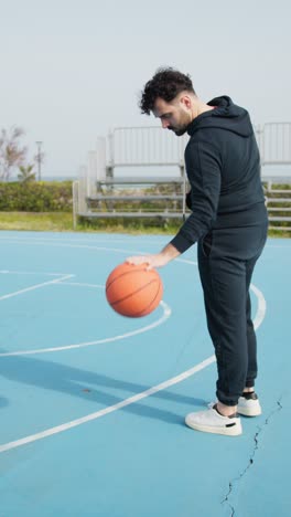 man practicing basketball on outdoor court
