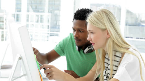 Attractive-colleagues-working-together-on-computer-