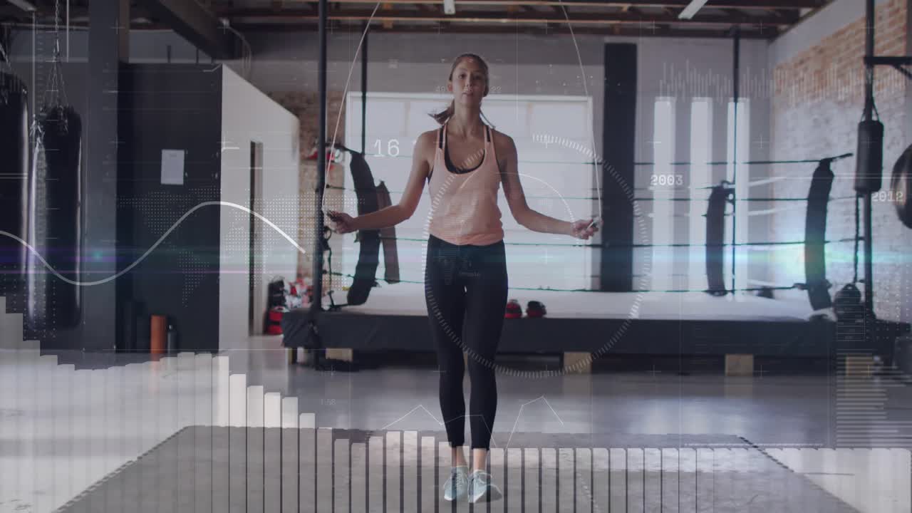 Woman swinging jump rope behind legs and activating pulsing digital fitness metrics in gym