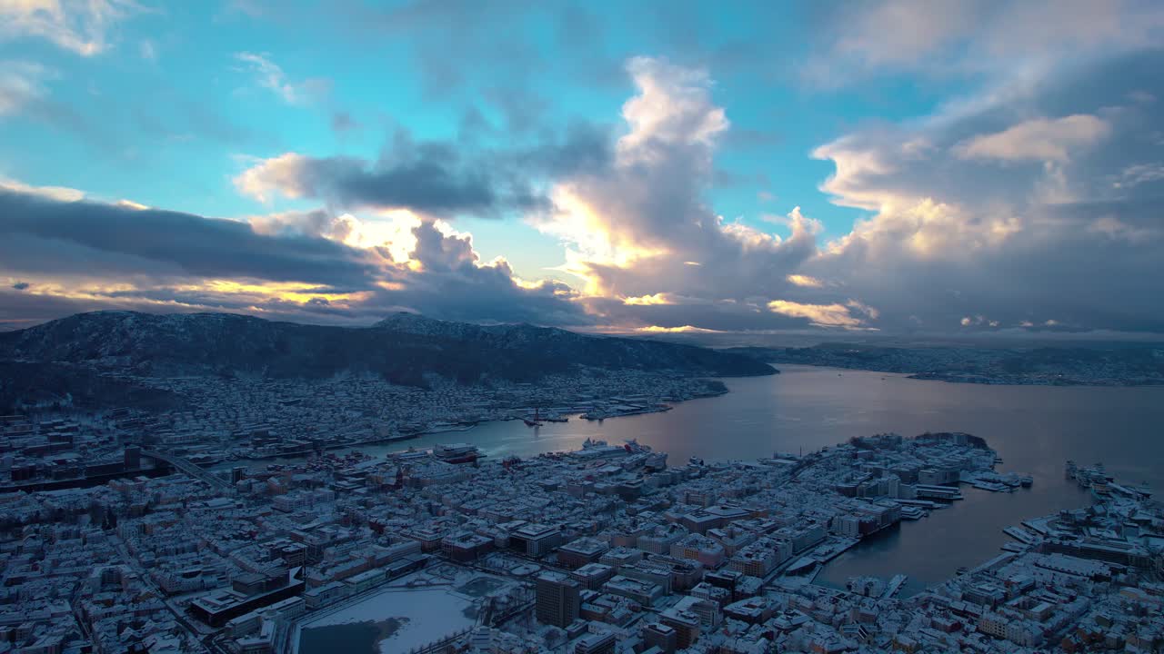 el paisaje épico de las nubes brilla amarillo desde la puesta del sol sobre bergen cubierto de nieve noruega