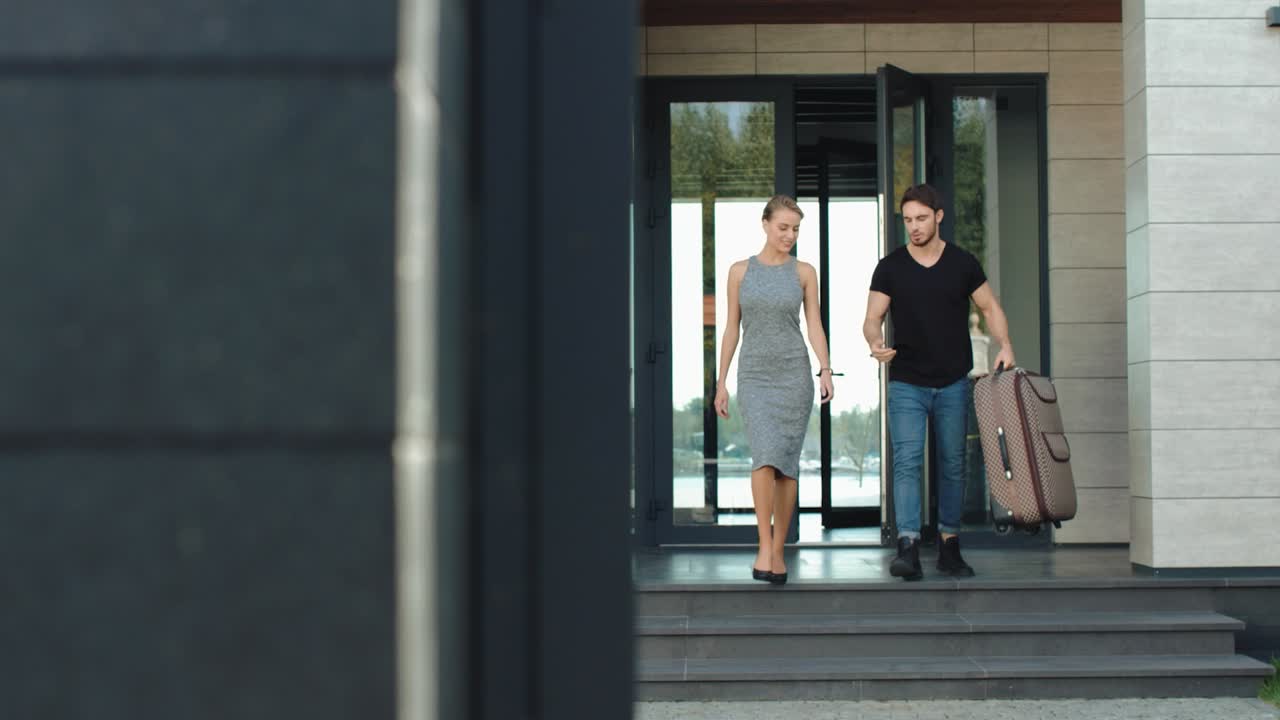 pareja segura saliendo de un edificio moderno. pareja rica en primer plano saliendo