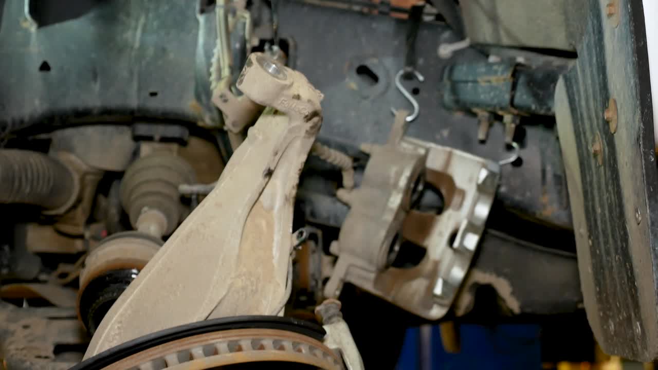 un movimiento de cámara inclinada que muestra los componentes de la suspensión delantera destrozados en un camión