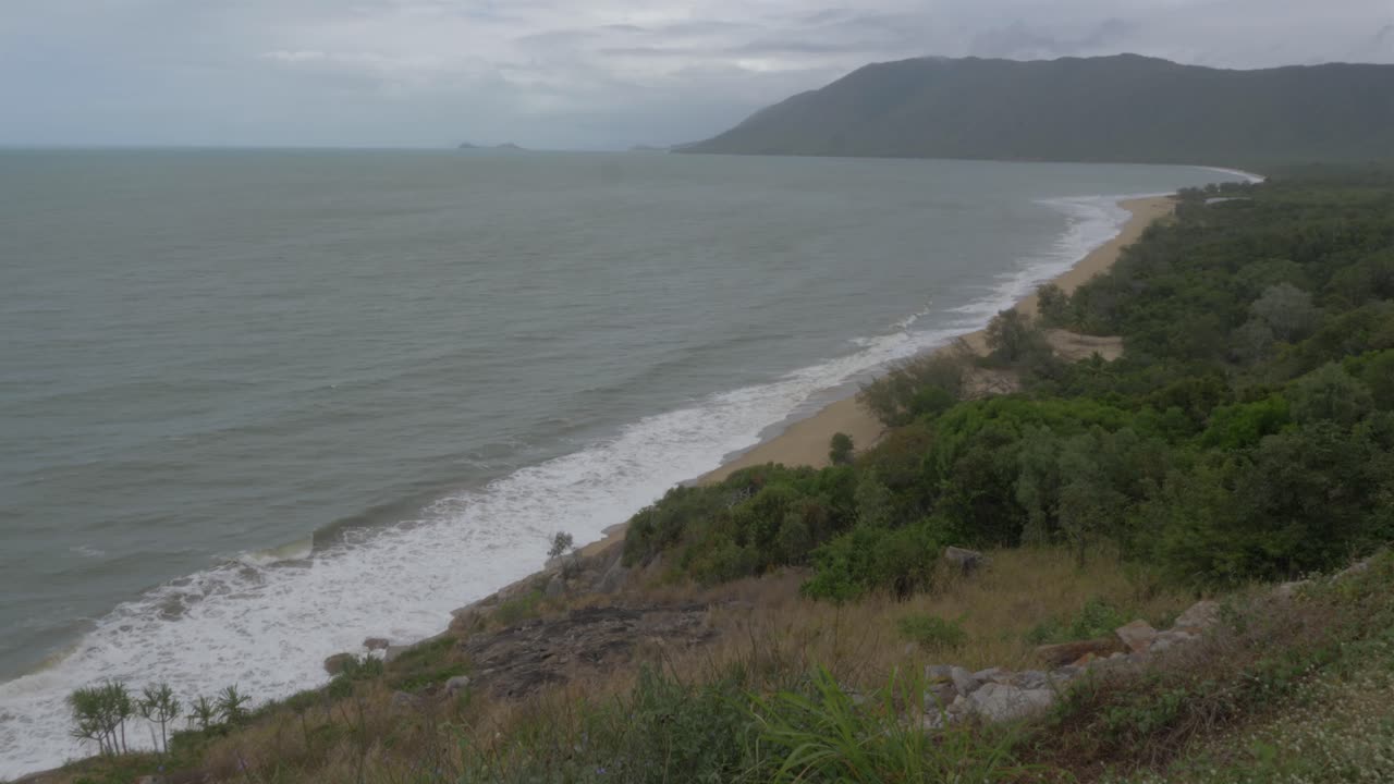 olas del océano rompiendo en la orilla de la playa en un día sombrío desde el mirador rex - lugar pintoresco en la autopista captain cook, wangetti, queensland, australia