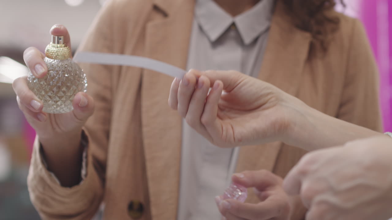 Women Spraying Perfume On Blotter
