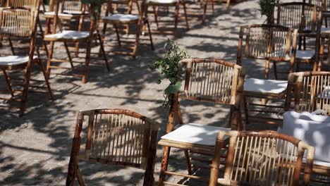 bamboo chairs with white cushions arranged for outdoor event